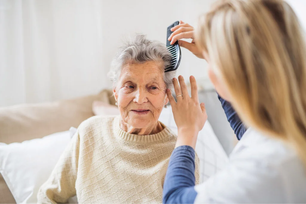 Happy old woman having her hair combed by younger woman. Atwell Care Ltd. Live in care. Home Care. Care Company. Bath. Frome. Keynsham. Saltford.